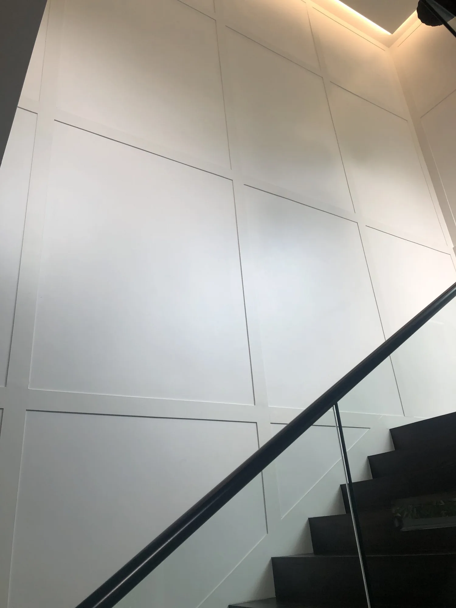 Full-height architectural wall panelling beside a staircase